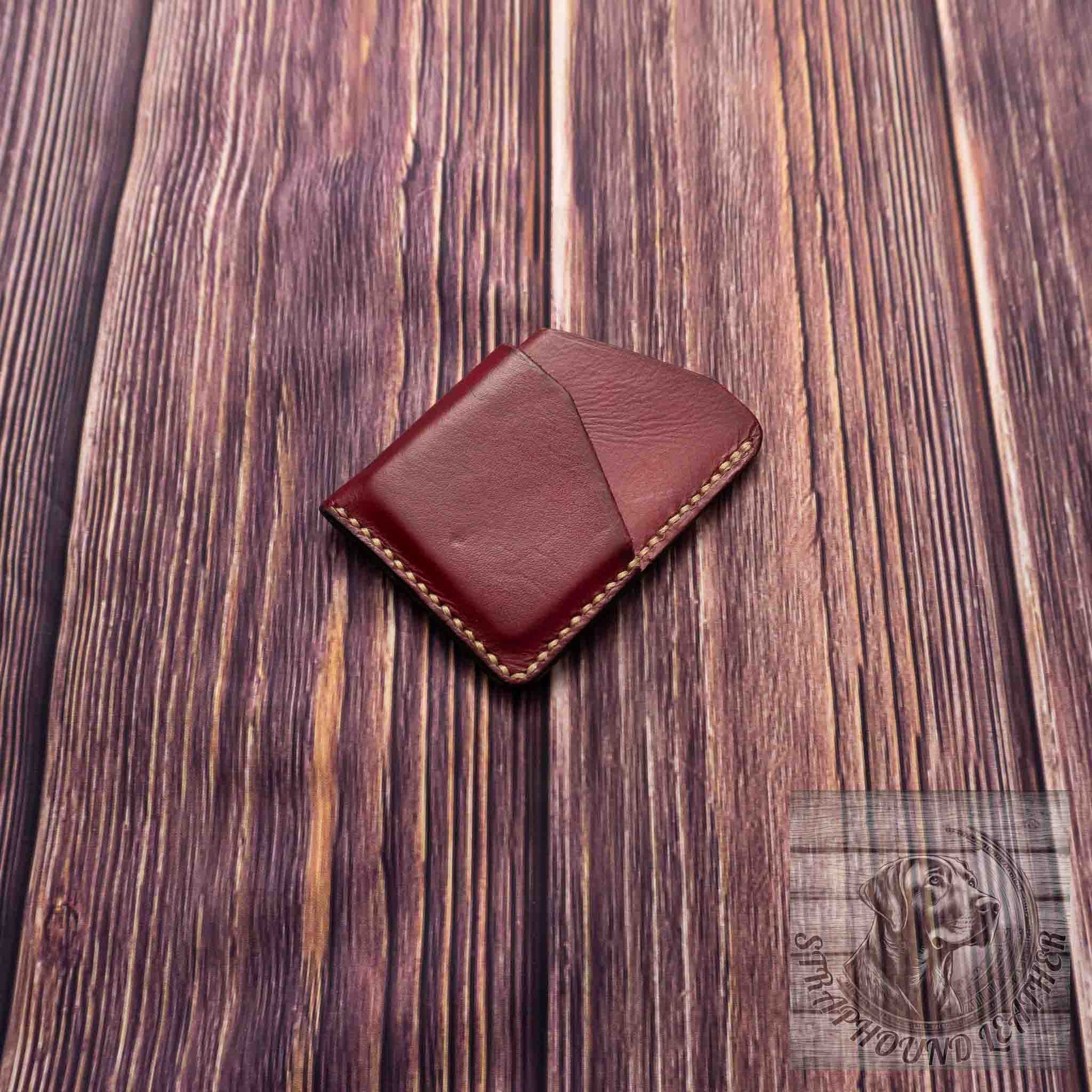 photo showing an oxblood red minimalist wallet with a light colored thread. 